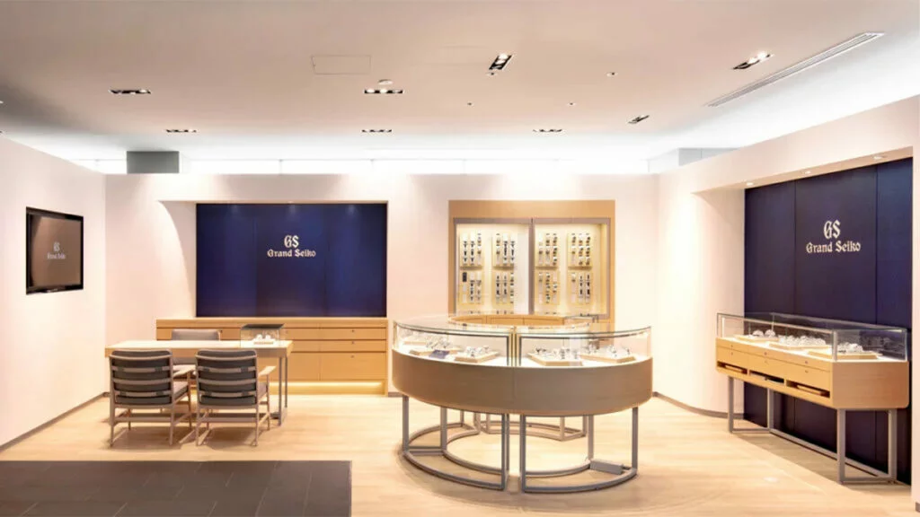 ハラダのグランドセイコーサロンの店内。紺の壁にGrand Seikoのロゴと時計の展示ケースが並ぶ
